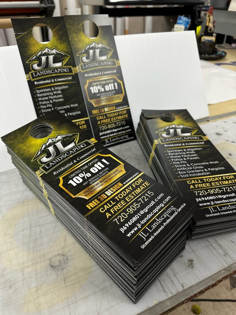 Stacks of custom printed door hangers for a landscaping company, printed by ASD Printing